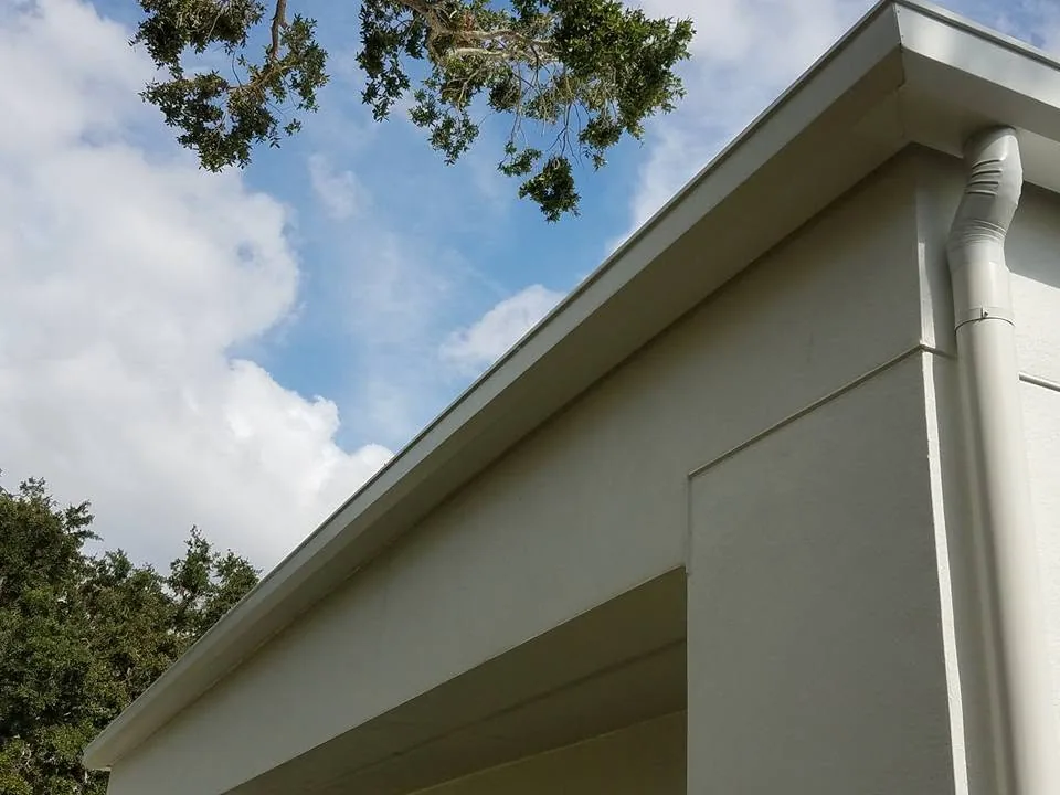 Low angle white fascia gutter round downspout stucco corner oak, Sanford